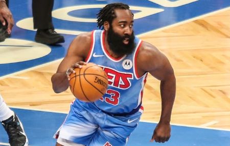 James Harden in a Nets jersey dribbling the ball.